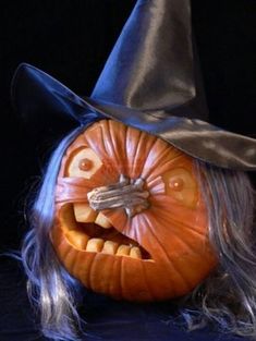 a halloween pumpkin with a witch hat on it's head and long hair in front of a black background