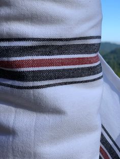 a person wearing a white shirt with red and black stripes on it's sleeves