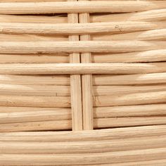 a close up view of the top of a wicker basket with wood strips on it