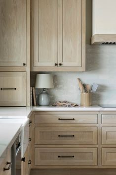 a kitchen with wooden cabinets and white counter tops, along with a lamp on the side