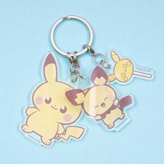 two keychains with cartoon characters on them, one is yellow and the other is pink