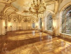 an empty ballroom with chandelier and stained glass windows