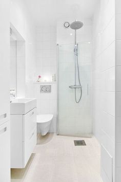 a white bathroom with a shower, sink and toilet