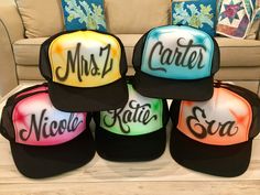 four hats with the words miss and mister written on them in different colors, sitting next to a couch