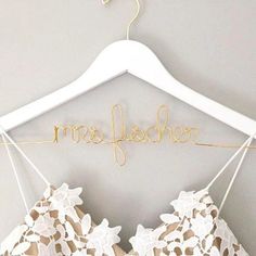 a bra hanging on a clothes hanger with the word scribbles written in gold