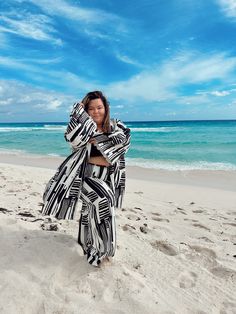 Plus size woman walks along the beach in Cancun, Mexico wearing flowy resort wear / vacation outfit.