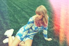 a woman sitting in the grass with her legs crossed