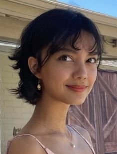 a woman in a pink dress is smiling at the camera