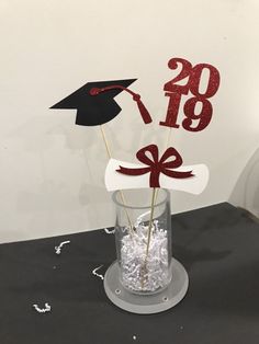 a graduation cake topper in a glass vase