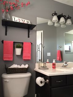 a white toilet sitting under a bathroom mirror next to a sink and a bath tub