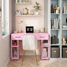 a pink desk in front of a bookcase filled with books and other items on shelves