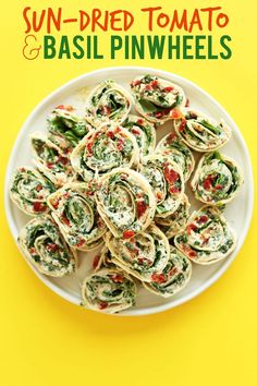 spinach and basil pinwheels on a plate with the title sun dried tomato & basil pinwheels