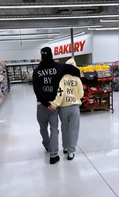 a man in a black hoodie is walking down the aisle with his back turned to the camera