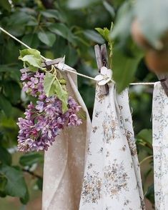 three cloths hanging on a clothes line with purple flowers