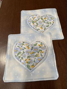 two heart shaped appliques are sitting on a table