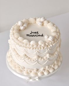 a white wedding cake with the words just married on it's frosting icing