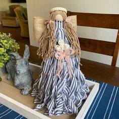 a wooden table topped with two stuffed animals next to flowers and potted plants on top of it