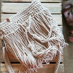 a white purse sitting on top of a wooden pallet