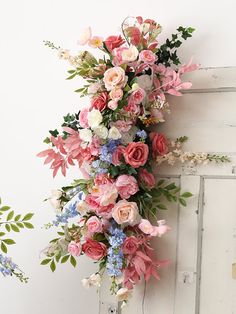 a bunch of flowers that are on the side of a door frame and hanging from it's sides