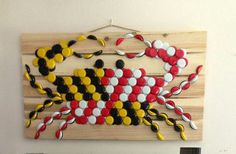 a crab made out of buttons is hanging on the wall