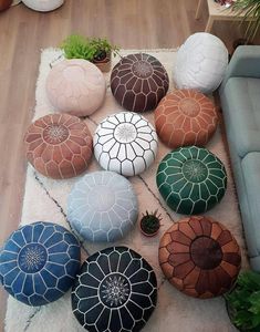 a living room filled with lots of different colored poufles on top of a rug