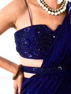 A three-piece Nikasha Blue Ruffle Saree Set from the Rashika Sharma collection. This beautiful dark blue ruffle saree in chiffon-organza fabric is paired with a chiffon embroidered bustier with straps. The outfit is completed with an embroidered belt. The beads, nakshi, zari, sequins, mirror and resham work enhance the Nikasha Blue Ruffle Saree Set.
Clutch NOT included
Ready to ship size: Small, Medium
Ships in 1 week. Ruffle Saree With Belt, Bustier Blouse, Saree Chiffon, Embroidered Bustier, Dark Blue Blouse, Dressing Design, Saree With Belt, Organza Lehenga, Ruffle Saree