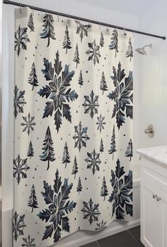 a shower curtain with blue and white snowflakes on it in a bathroom next to a sink