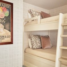 there is a poster on the wall above the bunk beds in this room with two pillows