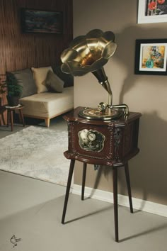 an old fashioned record player sitting on top of a wooden stand next to a couch