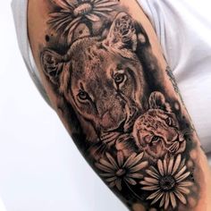 a woman with a lion and flowers tattoo on her arm