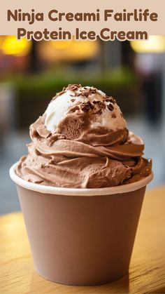 a cup filled with chocolate ice cream on top of a wooden table