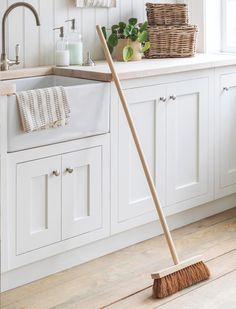 a broom in the middle of a kitchen floor