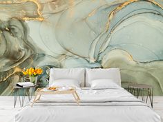 a bed sitting in front of a wall covered in gold and blue marbles on it's side