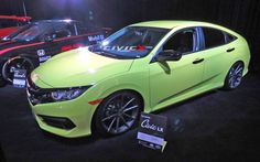 a lime green car is on display at an auto show with other cars in the background