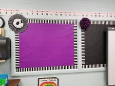 a bulletin board with purple and black paper hanging on it's wall in a classroom