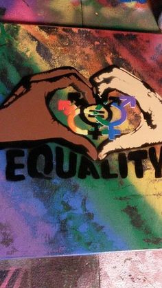 the word equality painted on top of a skateboard in front of a colorful background