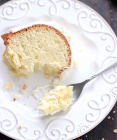 a piece of cake on a white plate with a fork next to it and another slice missing