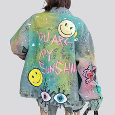 the back of a woman's jean jacket with smiley faces and words painted on it