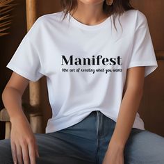 This t-shirt is more than just clothing, it's a statement and a reminder! The bold text design "Manifest, the art of creating what you want" declares your belief in the power of positive intention. Shirt available in 9 colours: Orange, Heather Prism Peach, Pink, Ocean Blue, Soft Cream, Yellow, Ash, Citron & White 💫 💡 Click here to see all of our Inspiration Apparel items 💡 💫 https://www.etsy.com/uk/shop/AllGoodVibesDesigns?ref=shop-header-name&listing_id=1740563393 🎁 💫 💡 Click here to see White Crew Neck T-shirt With Quote, Quote Print Crew Neck Tops For Streetwear, Crew Neck Top With Quote Print For Streetwear, Relaxed Fit Crew Neck T-shirt With Quote Print, Inspirational Crew Neck Tops With Letter Print, Inspirational Crew Neck Top With Quote Print, Inspirational Slogan Crew Neck Shirt, Inspirational Quote Print Crew Neck Top, Inspirational Quote Print Top With Relaxed Fit