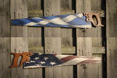 two pairs of scissors and an american flag ribbon on a wooden fence, with the handles cut off