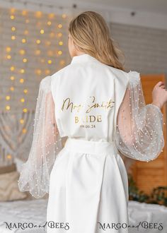 the back of a bride's wedding robe with her name on it and beaded sleeves