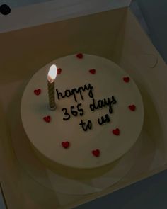 a birthday cake with a lit candle on it that says happy 365 days to us