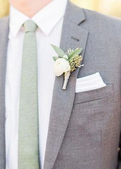 a man in a suit and tie with a boutonniere on his lapel