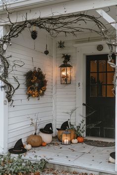 the front porch is decorated for halloween with pumpkins and other decorations