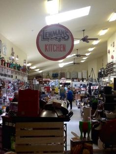 the inside of a store filled with lots of furniture and decor, including signs that read herman's kitchen