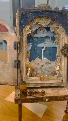 an elaborately decorated clock on display in a museum setting with wooden floors and walls