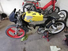 two bikes parked next to each other in a garage with red and yellow rims