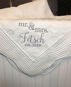 a white towel hanging on the side of a wall with mr and mrs written on it