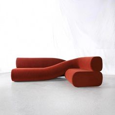 a red couch sitting on top of a white floor