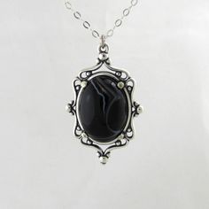 This pendant is a 20 mm x 30 mm sterling silver setting with a 18 mm x 13 mm black onyx, aged to resemble an heirloom piece. This perfectly matches my black Agate ring and is a beautiful gift given as a set.   Each cameo necklace comes with a 16 inch silver chain. If you require a longer chain, please include this information at checkout. For any other custom orders or requests. All items come with free repair, resize and maintenance for the life of the product, including replacement of the came Antique Black Oval Cabochon Jewelry, Black Oval Jewelry With Large Pendant, Antique Black Sterling Silver Necklace, Onyx Jewelry With Large Stone For Gift, Collectible Black Jewelry With Large Pendant, Black Oval Agate Jewelry, Black Sterling Silver Jewelry With Oval Cabochon, Black Oval Cabochon Sterling Silver Jewelry, Handmade Black Jewelry For Memorial